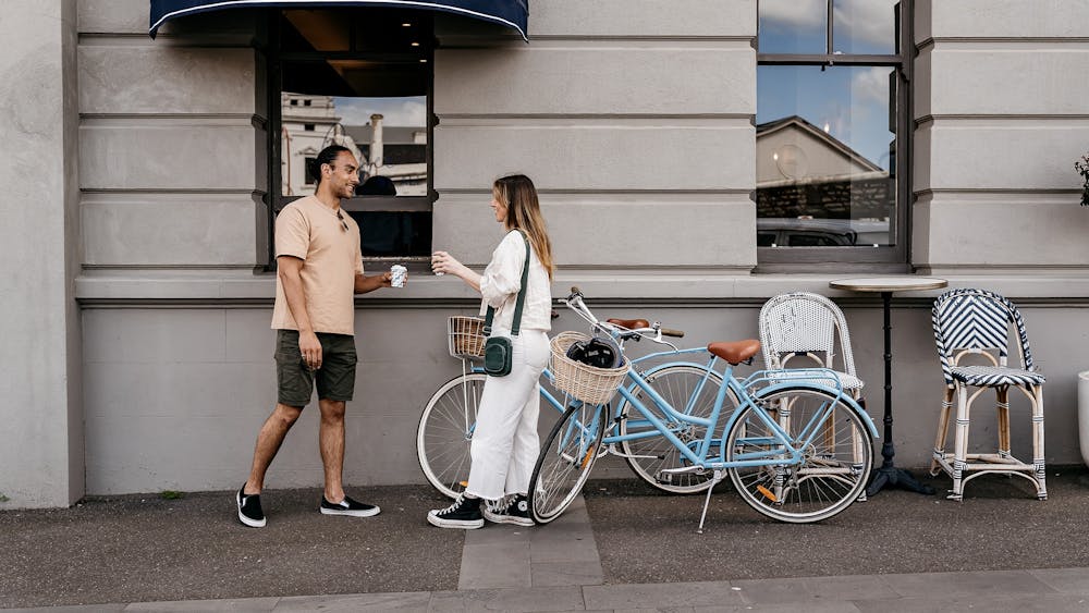 two people order a coffee next to their bikes