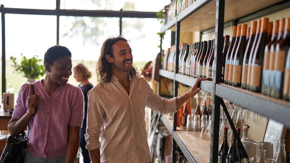 Couple perusing wine bottles in a cellardoor