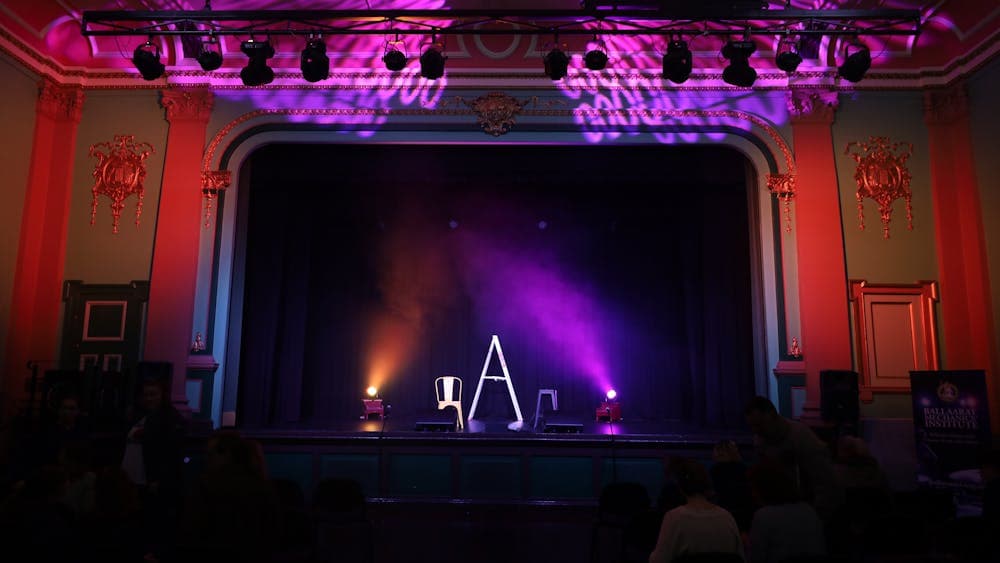 Minerva Space before a theatre show. There is a ladder on the stage & purple lights on the ceiling.