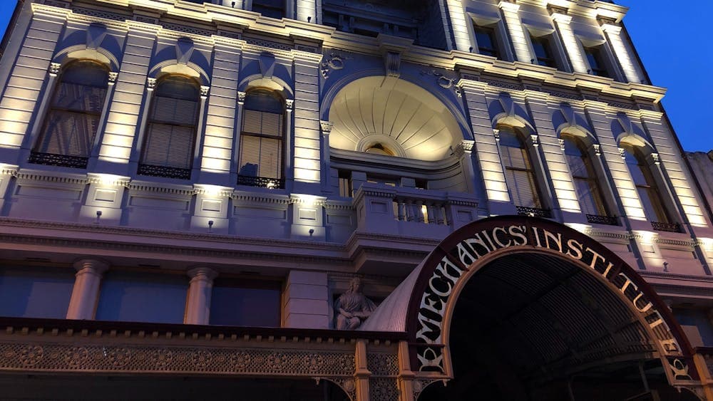 Facade of the BMI building at dusk with lights highlighting the pillars.