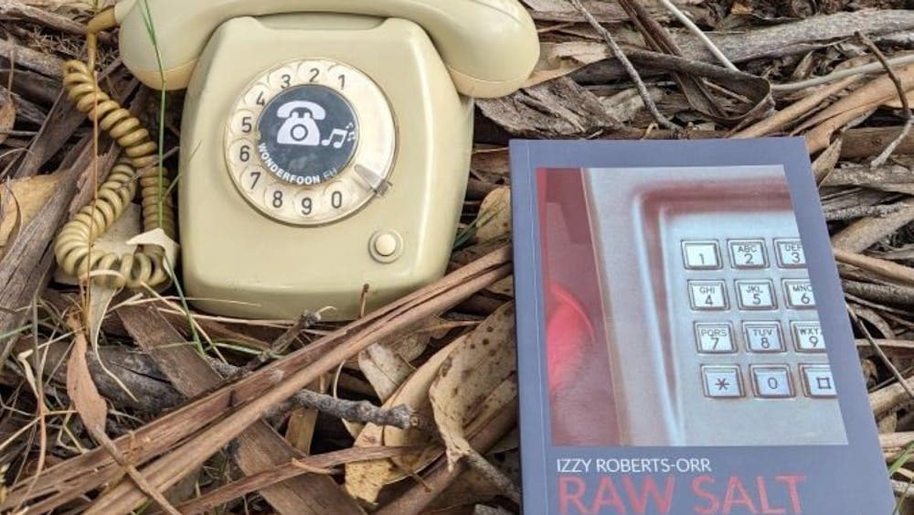 An old handheld telephone with a book.