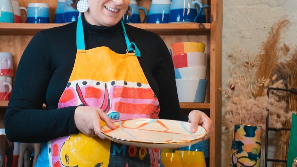 Ruby holding a plate in her studio