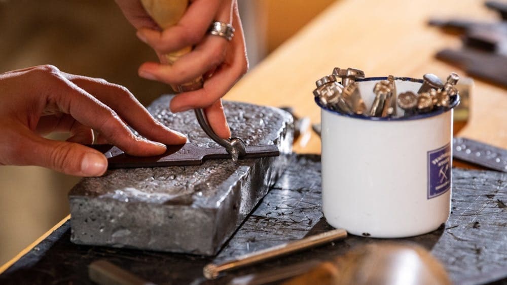 Close up of hands making leather keyring