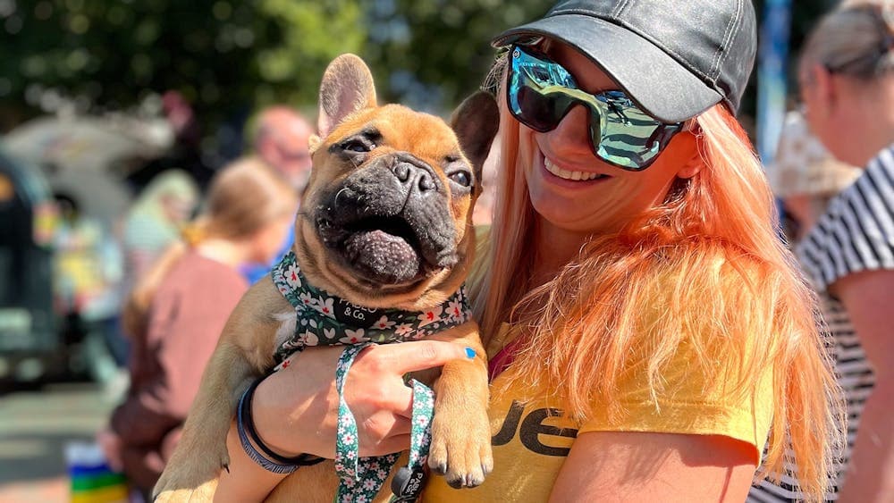 Woman holding dog amongst a crowd