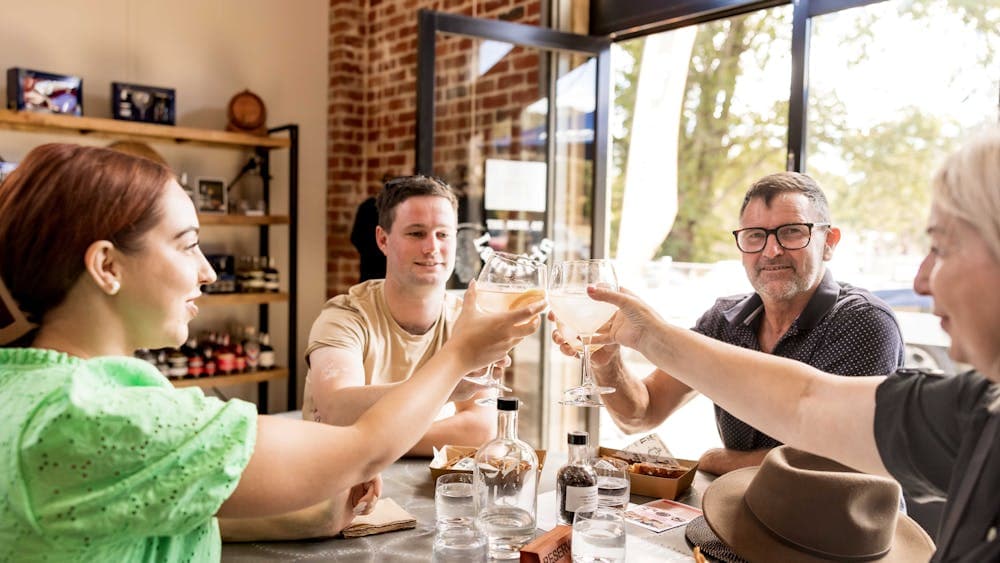 group of four raising their glasses for a toast