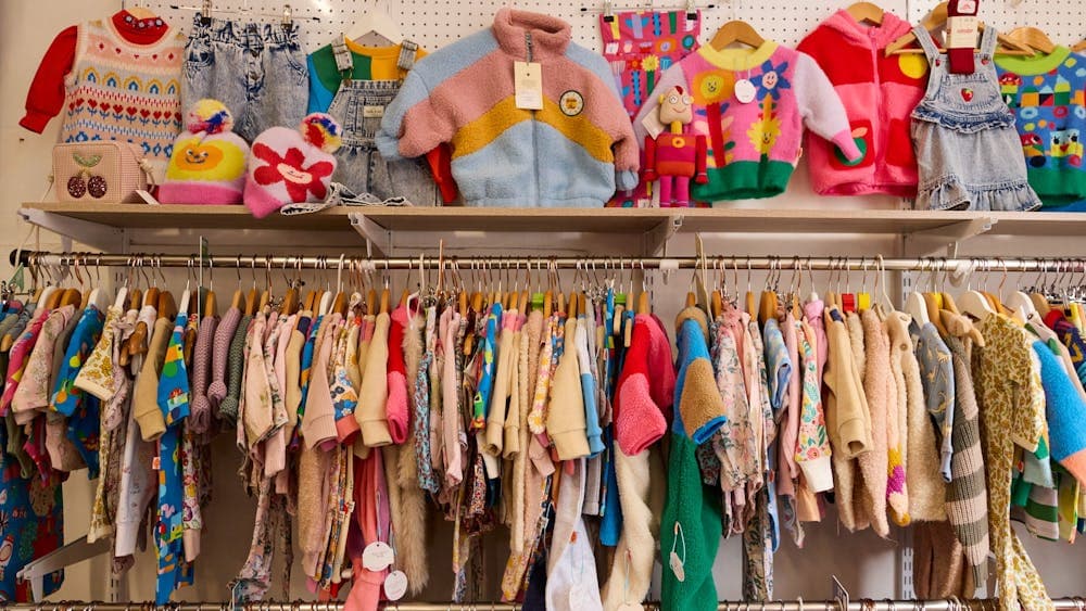 image shows brightly coloured kids clothing hanging on the racks.