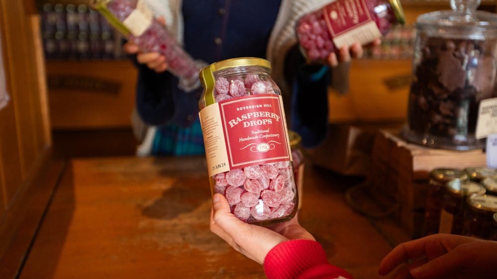 Hand holding jar of Raspberry Drops