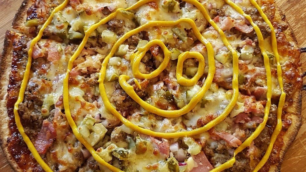 Cheeseburger pizza with smiley face sauce swirl