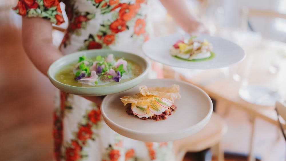 person carrying 3 plates of food