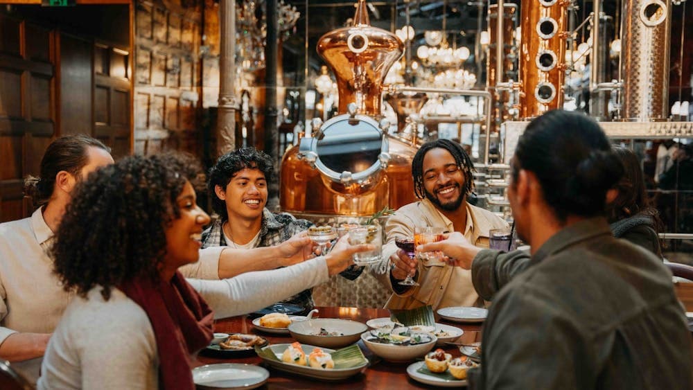 group of people in a venue, clinking their glasses together