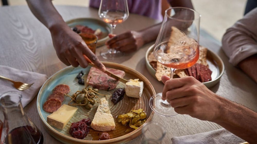 2 people share a grazing board and wine