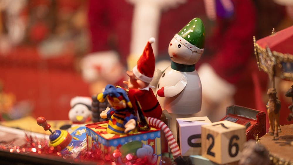 A small elf and snowman play with a jack-in-the-box inside the Emporium