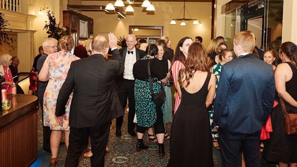 People having a wonderful time at the bar in the foyer of the theatre