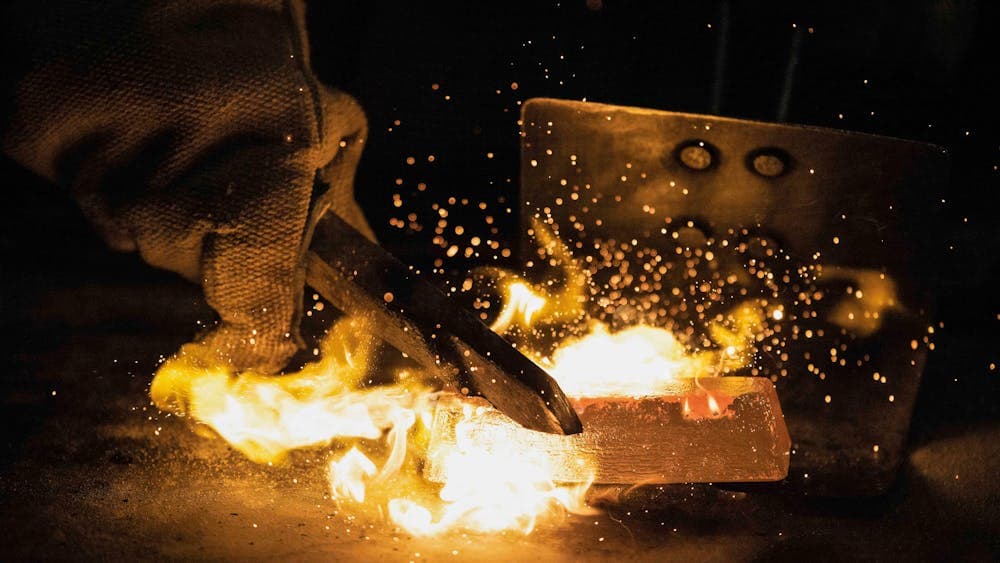 Close up of gold bar ignited by fire during gold pour demonstration