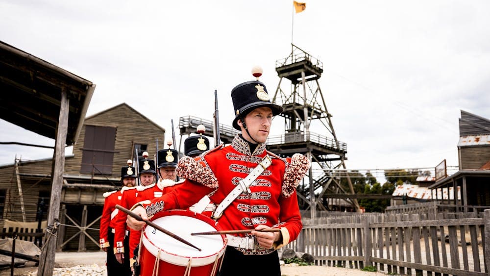 Redcoat soldiers lined up in front of Sovereign Hill's poppet head