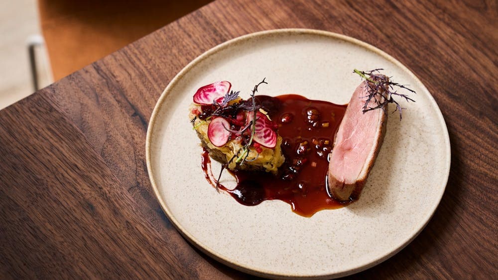 Plate of corn fed duck, wolf berries, Savoy cabbage parcel of pearl barley