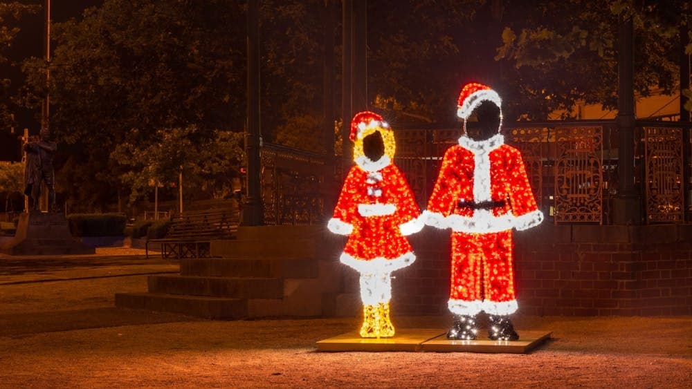 Santa and Mrs Clause are illuminated with bright fairy lights