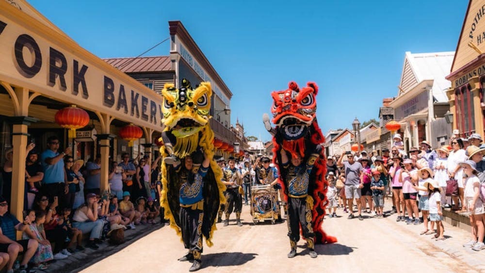 Chinese dragon and lion dance in Sovereign Hill's Main Street surrounded by crowd of onlookers