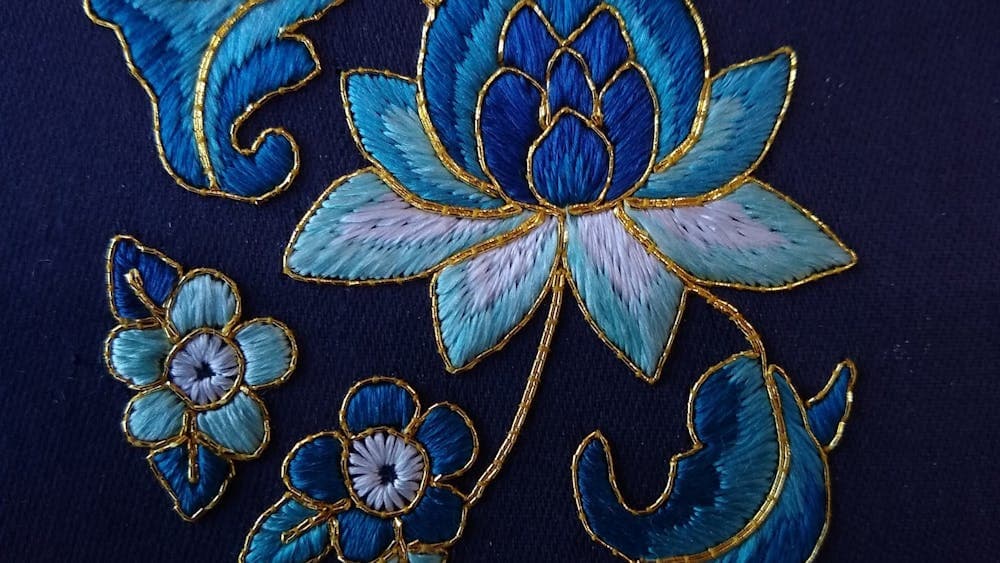 Blue floral embroidery on blue fabric