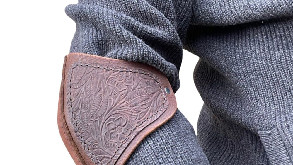 Person wearing elaborately designed leather elbowguard