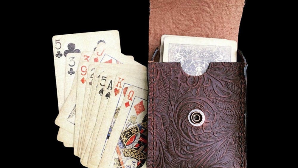 Leather pouch containing deck of cards with other cards laid out beside it