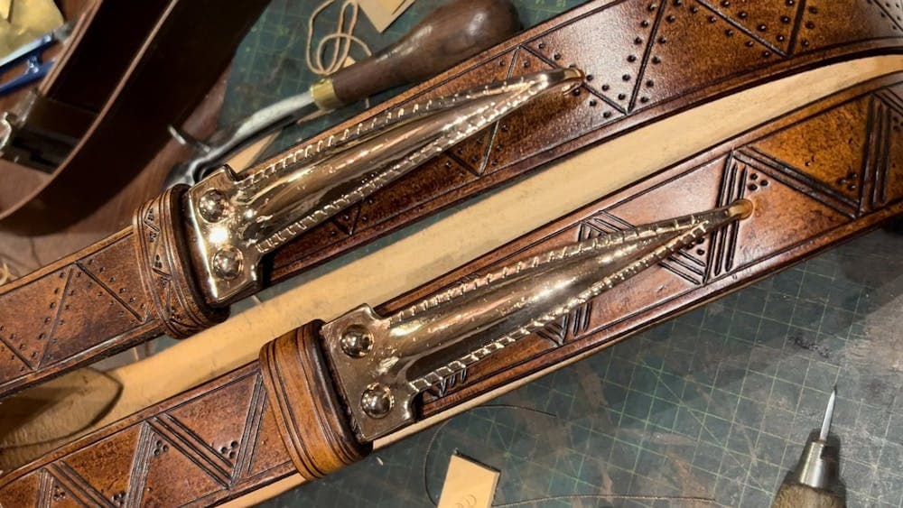 Leather belts with cast bronze designs