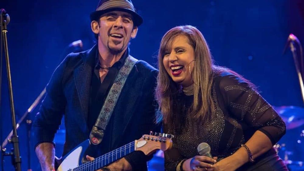 Andrea Marr and John McNamara performing on stage laughing