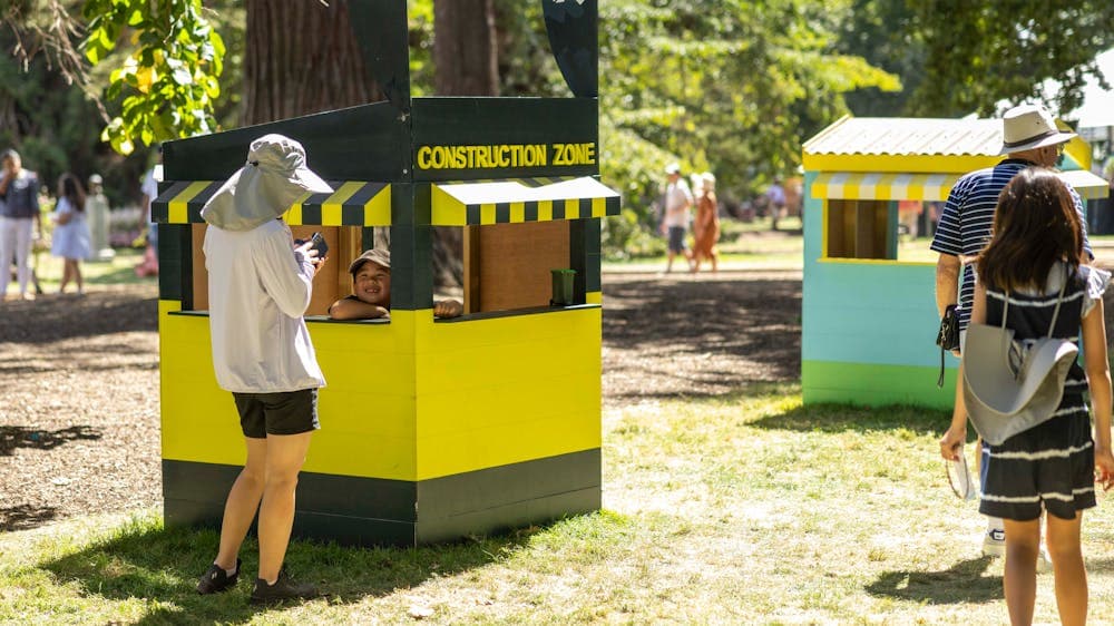 A small cubby house decorated in yellow and black as a construction zone