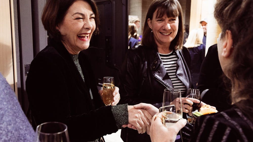 Group of people talking while holding  drinks