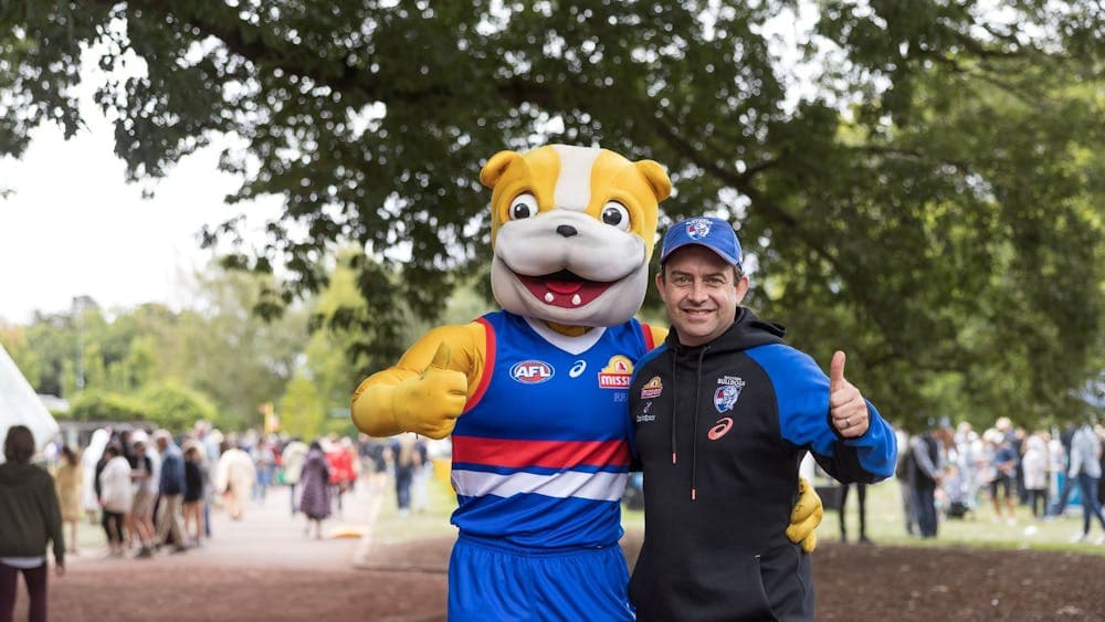 A Western Bulldogs mascot stands with a man in a Western Bulldogs jumper