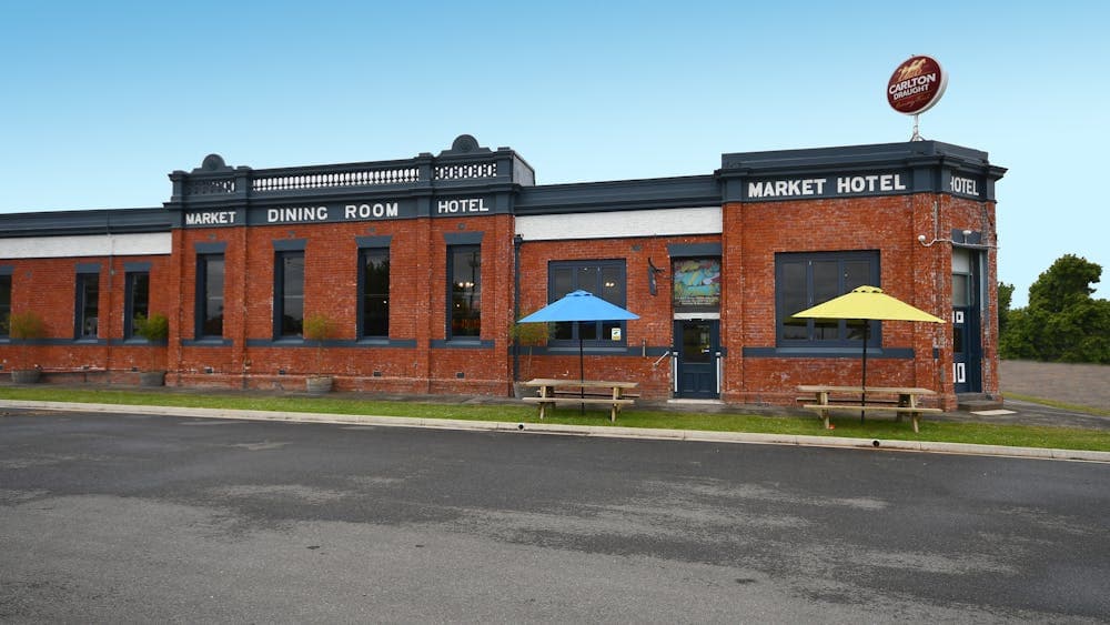 Street view of the Market Hotel. Red brick hotel with blue trim.