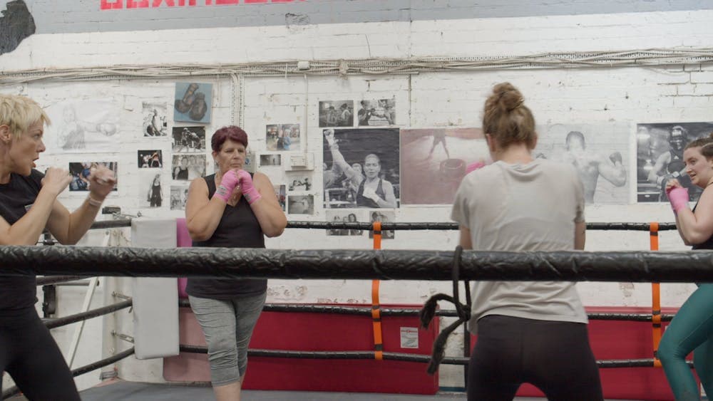 A group of women do boxing training in a gym