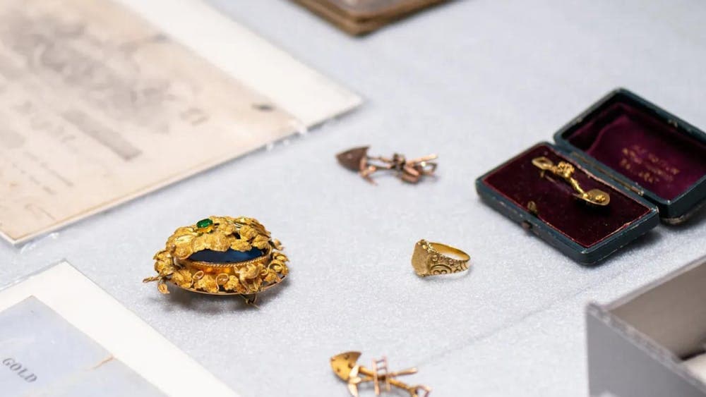 Collection of 19th century gold jewellery (pins and brooch) surrounded by documents