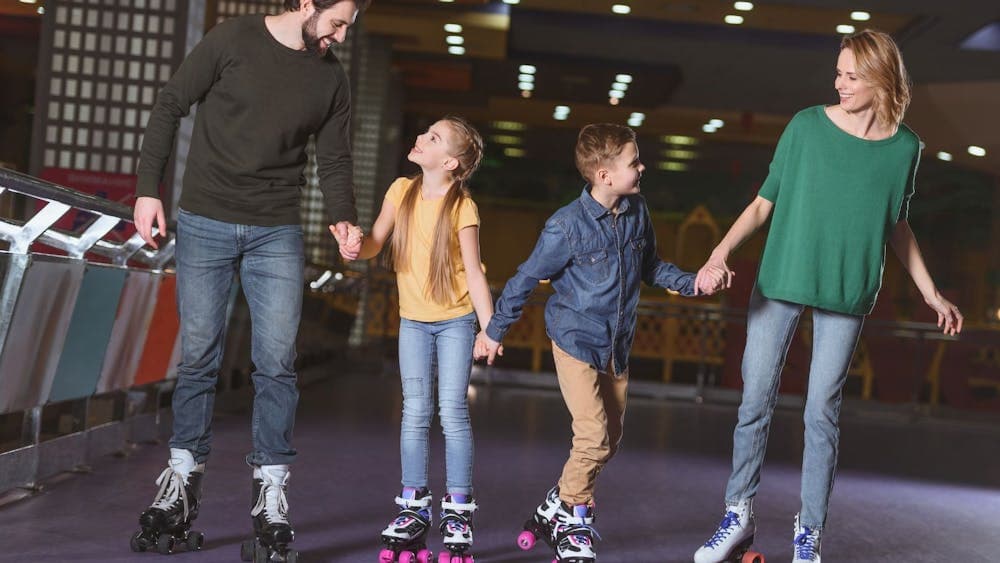 Family holding hands roller skating together