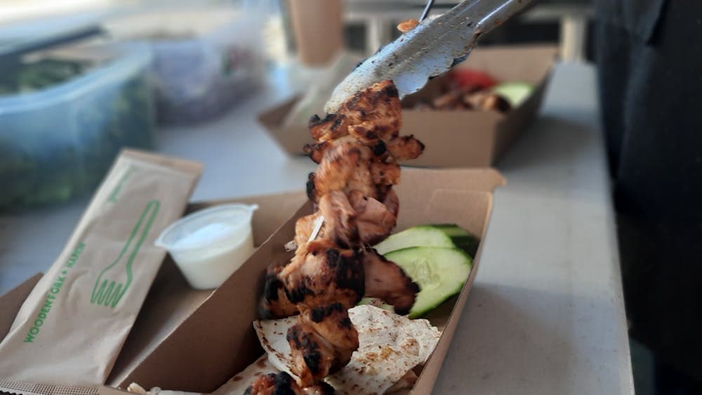 a kebab being placed into a cardboard box