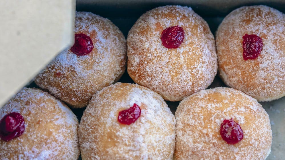 The donuts are artistically photographed in a box with the lid partly concealing them