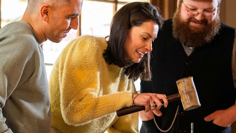 Man and woman making keyring with Sovereign Hill leather-maker inside workshop