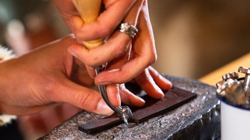 Close up of hands making leather keyring