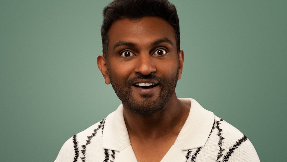 Nazeem Hussain in a white shirt on a green background