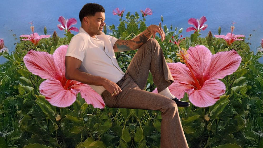 Guy Sebastian reclining on giant flowers